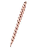 A metallic rose gold ballpoint pen with engraved floral patterns, shown diagonally on a solid white background.