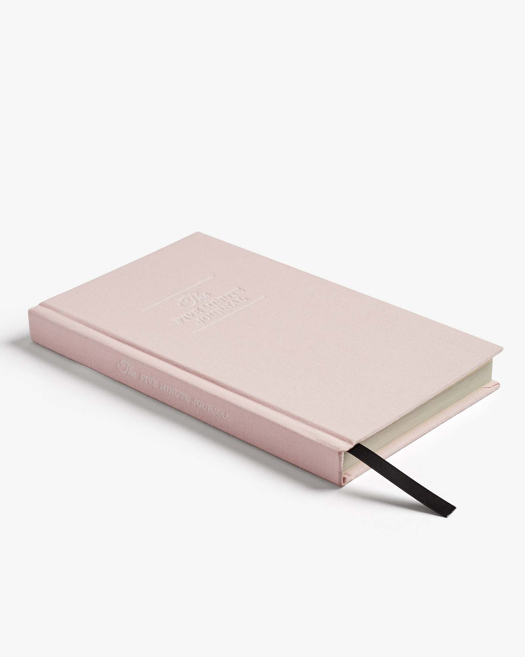 Soft pink hardcover girls daily journal labeled "The Five Minute Journal" in white letters with a black bookmark ribbon resting flat.