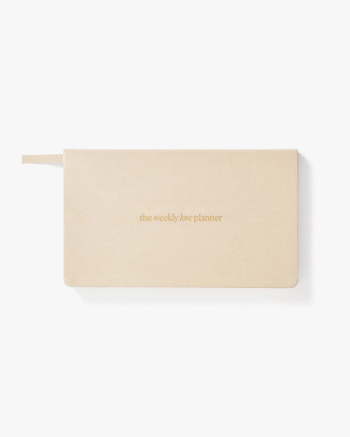 A light beige weekly planner with a matching ribbon bookmark, featuring the text 'the weekly love planner' in gold foil on the front, set against a clean white background.